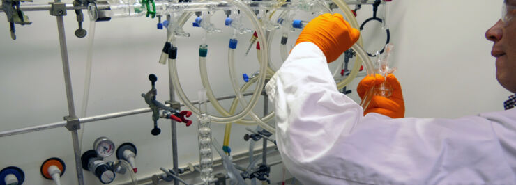 A man holding tubes in a chemistry lab.