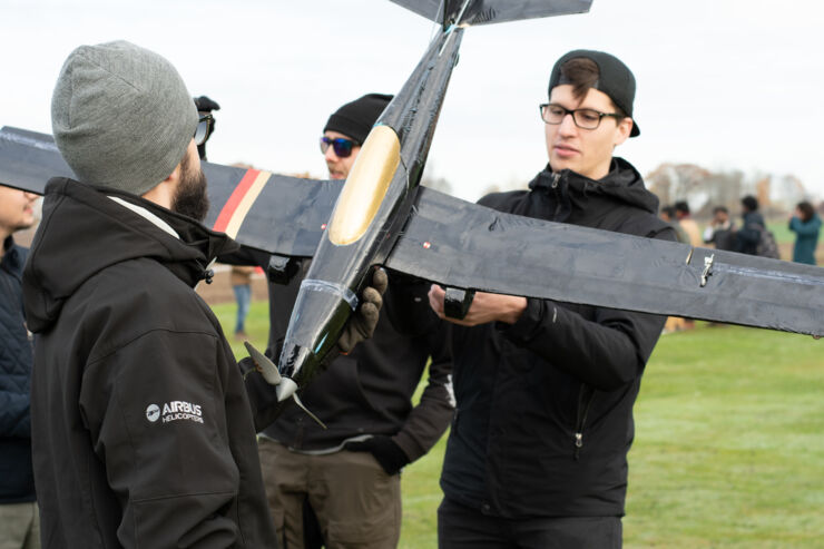 A student holds a modell air plane, which he is about to test