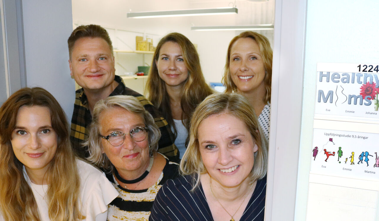 En grupp forskare som tittar ut från laboratoriet i en dörröppning. 