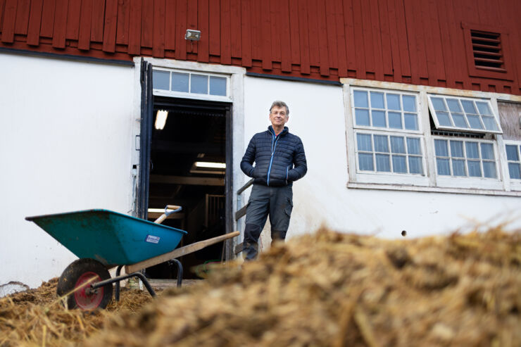Uno Wennergren in front of a stable and a pile of fertiliser.