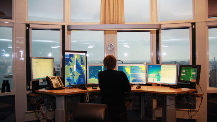 Women infront of computer screens at sea traffic hub.