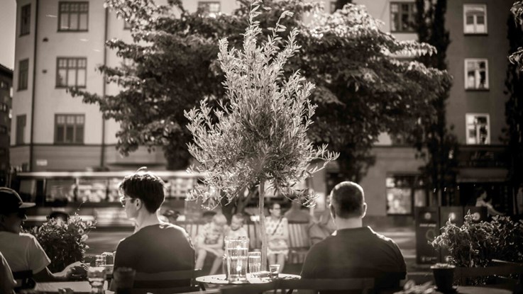 Bild från en stad med människor som sitter vid ett bord.