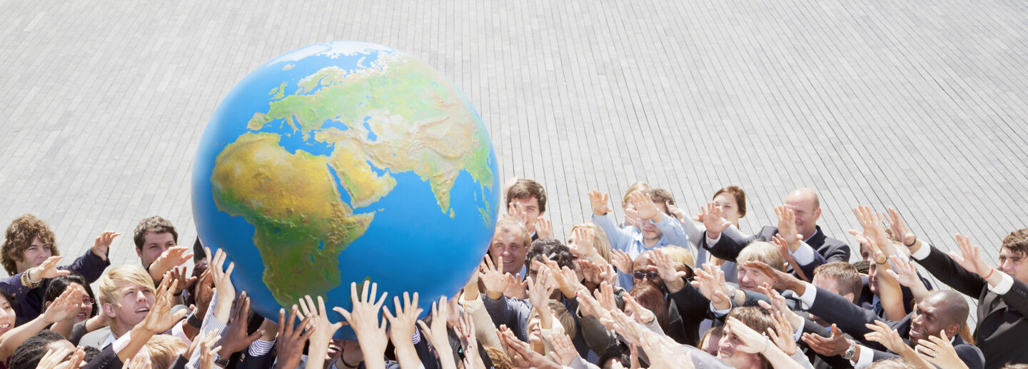 People lifting an earth globe
