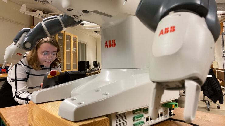 A two-armed robot is programmed by student.