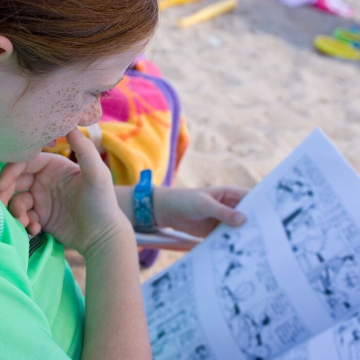 A girl reading on the beach.