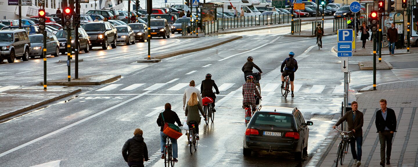 Människor cyklar vid Skeppsbron i Stockholm.