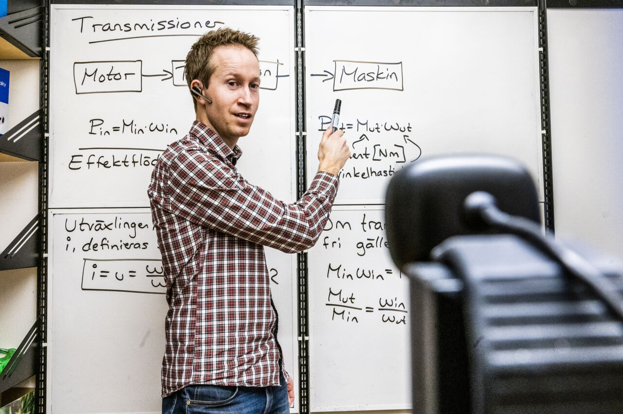 Mikael Axin föreläser på distans framför en whiteboard.