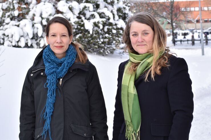 Forskarna Judith Lind och Anette Wickström framför ett träd med snö