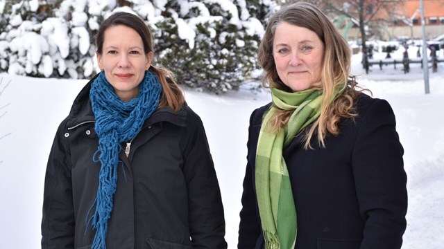 Forskarna Judith Lind och Anette Wickström framför ett träd med snö