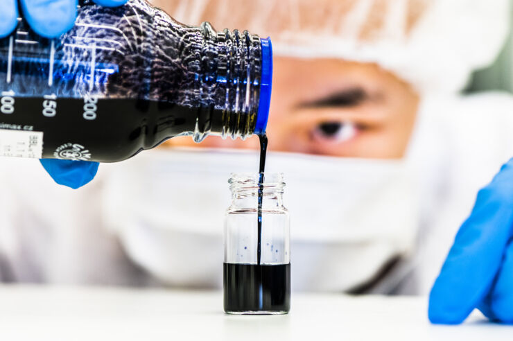 Researcher pours ink into a beaker.