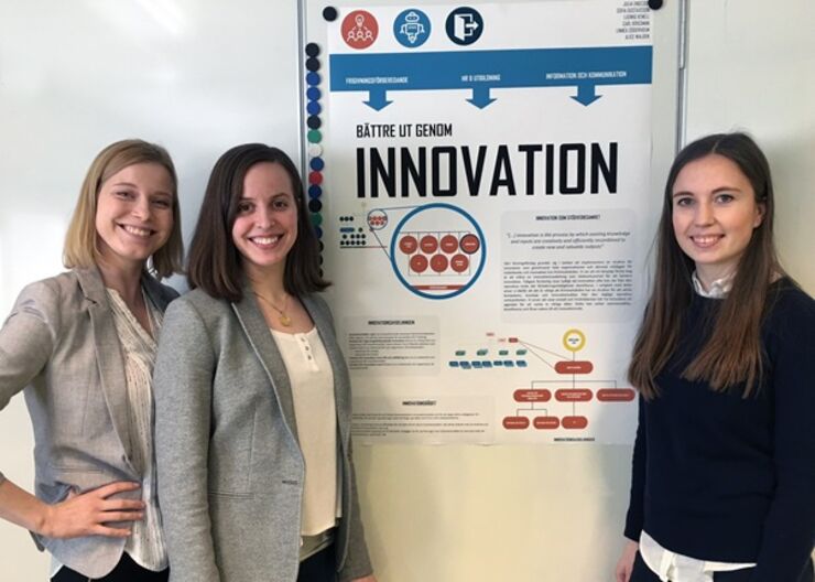 Three students by their poster 