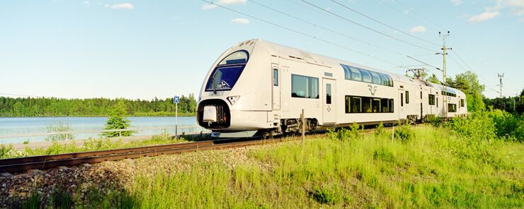 Ett SJ-tåg som kör genom ett vackert landskap.