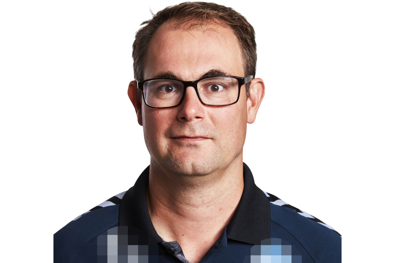 Portrait of Markus Waldén. He is wearing a darkblue piké shirt and the bakground is white.