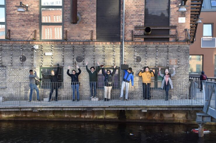 Group members photographed outside infront of a brick wall