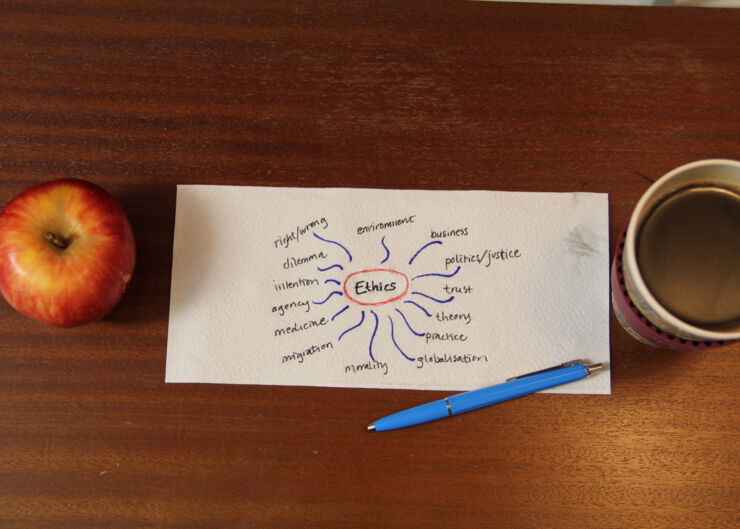 Paper napkin with mindmap scribbling. Red apple on the left and a mug of coffee on the right. Photo taken from above.