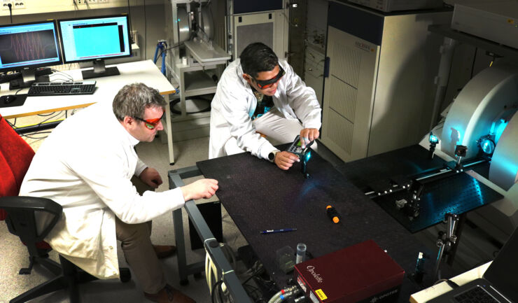 Two men in laboratory. Experimenting with light.