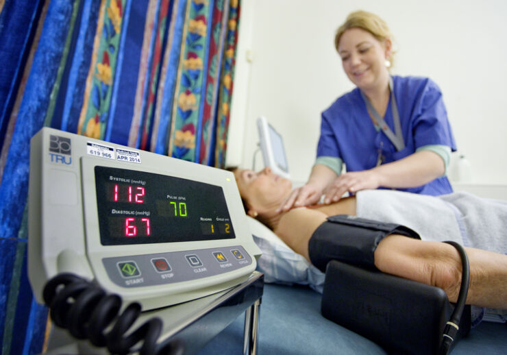 Fotografi av sjuksköterska som mäter blodtryck och puls på patient