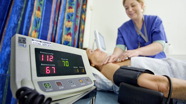 Fotografi av sjuksköterska som mäter blodtryck och puls på patient