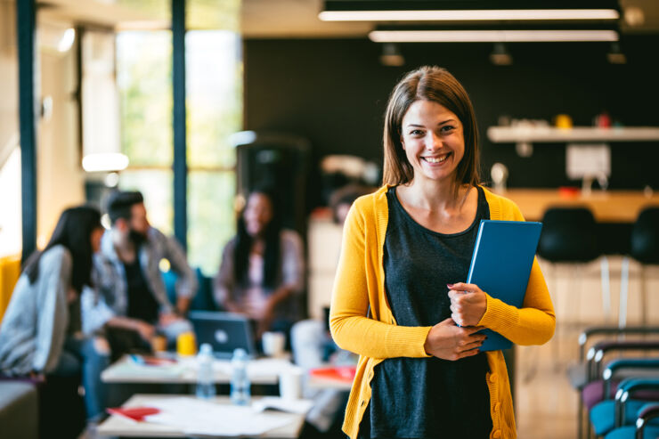 A girl with a yellow cardigan holds a book