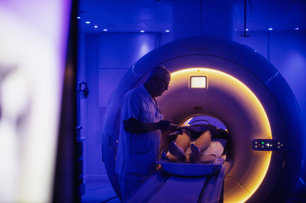 Photo of MR radiographer injecting contrast agents during an exam in the MR scanner