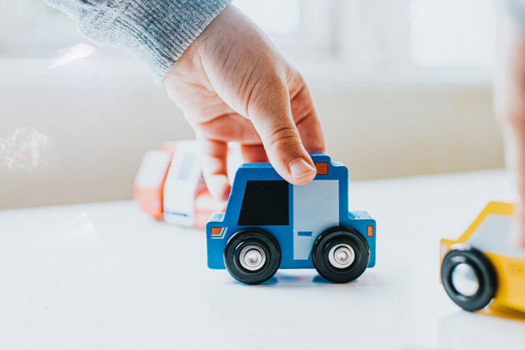 Barnhand håller leksakspolisbil