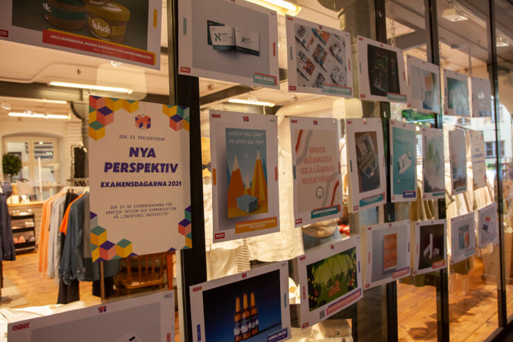 Posters med olika designalster uppsatta på en glasvägg