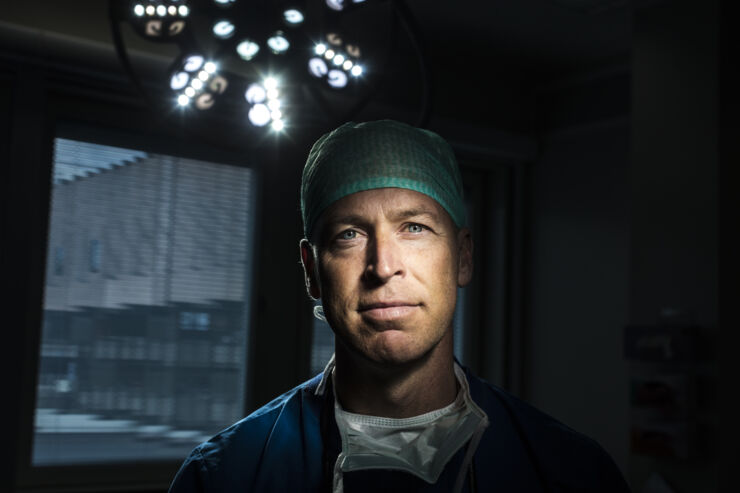 Simon Farnebo i operationskläder framför en kirurgilampa.