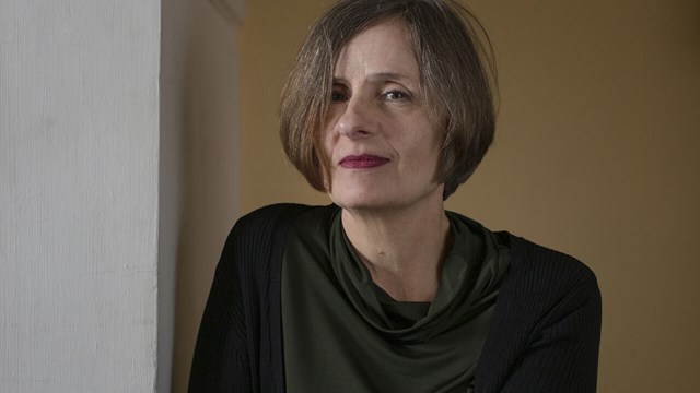 Porträttbild på Susanna Alakoski mot mörk bakgrund.