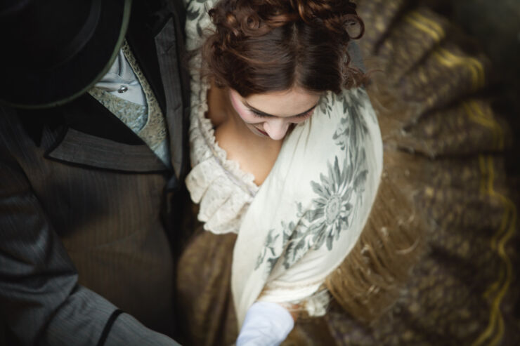 Victorian romantic couple whirls while dancing together.