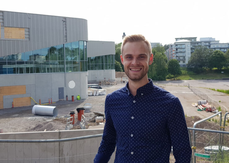 Young man in front of a building site