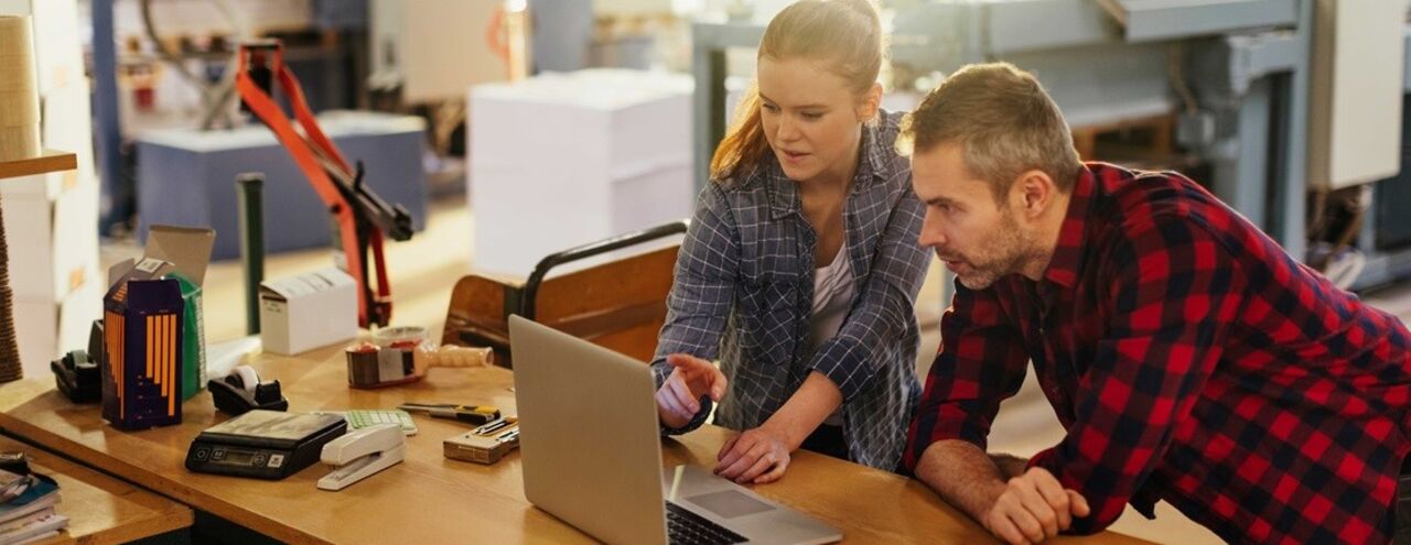 a Women is showing something on computer for a men. Working environment. 