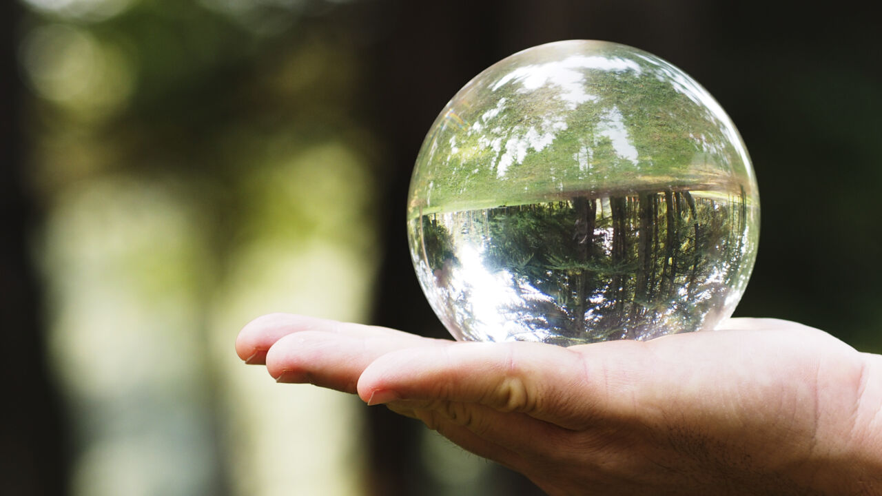 A hand is holding a glass bubble