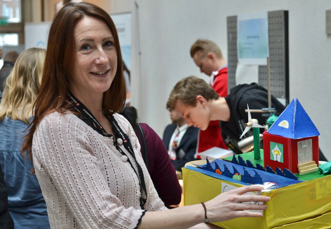 Lärare tittar in i kamera visar upp uppfinning.