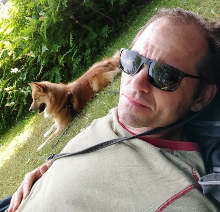 Bild på Gissur Erlingsson och en hund i gräset