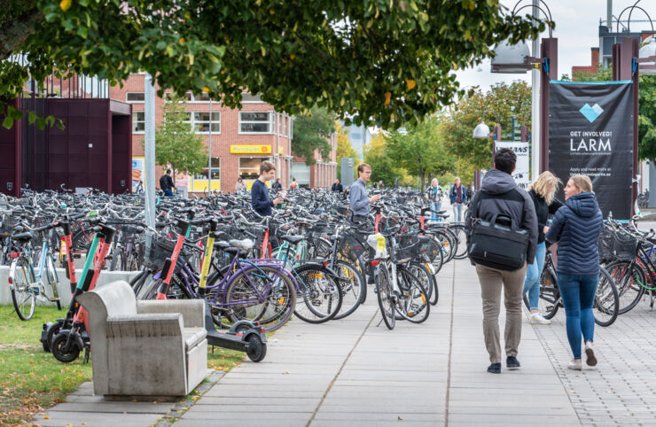Studenter bland parkerade cyklar på Campus Valla.