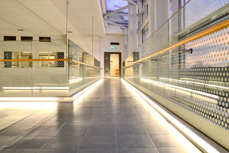 En glaskorridor som är upplyst längs med golvet.