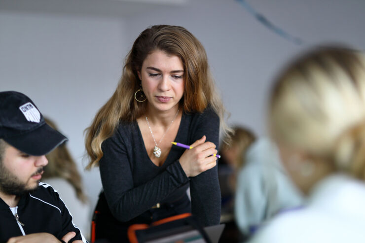 Lärarstudenten Kassandra undervisar två elever i gymnasiet.