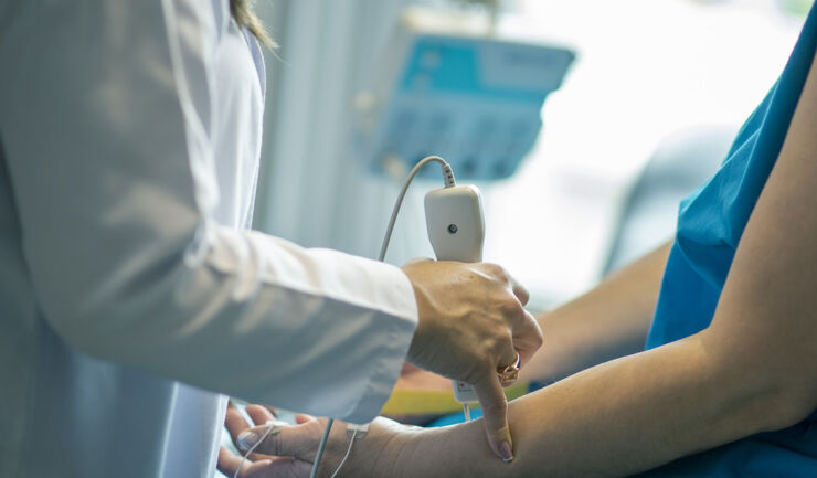 Photo of arm being palpated by nurse.