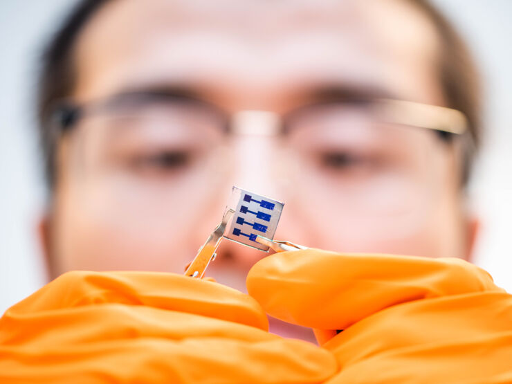 Rui Zhang holding a small solar cell