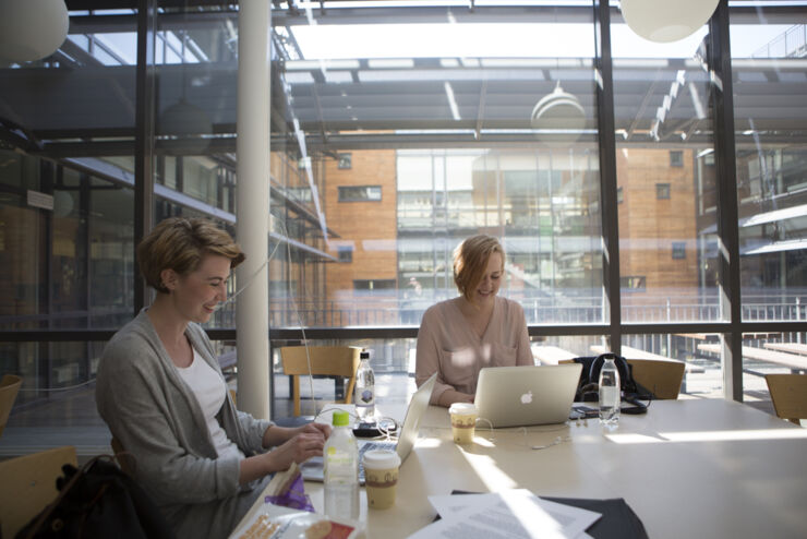 Två kvinnliga studenter vid ett bord