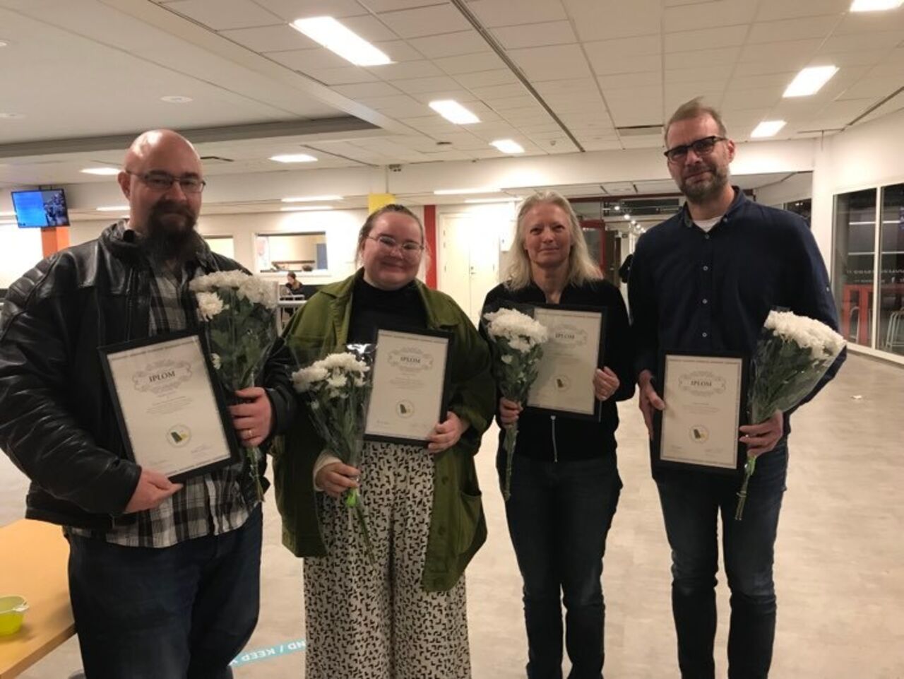 Fyra människor som fått pris diplom och blomma