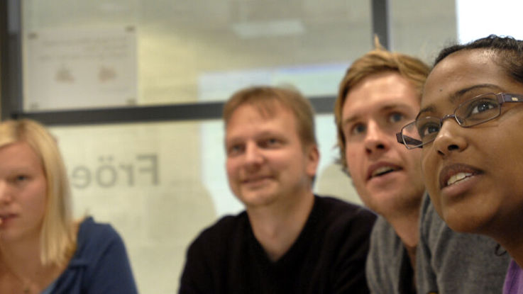 Close-up of four students looking upp at something beyond the camera