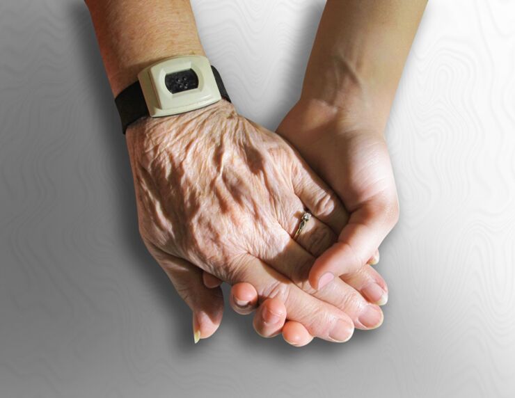 Close up of two person's hands. They are holding each others hands.