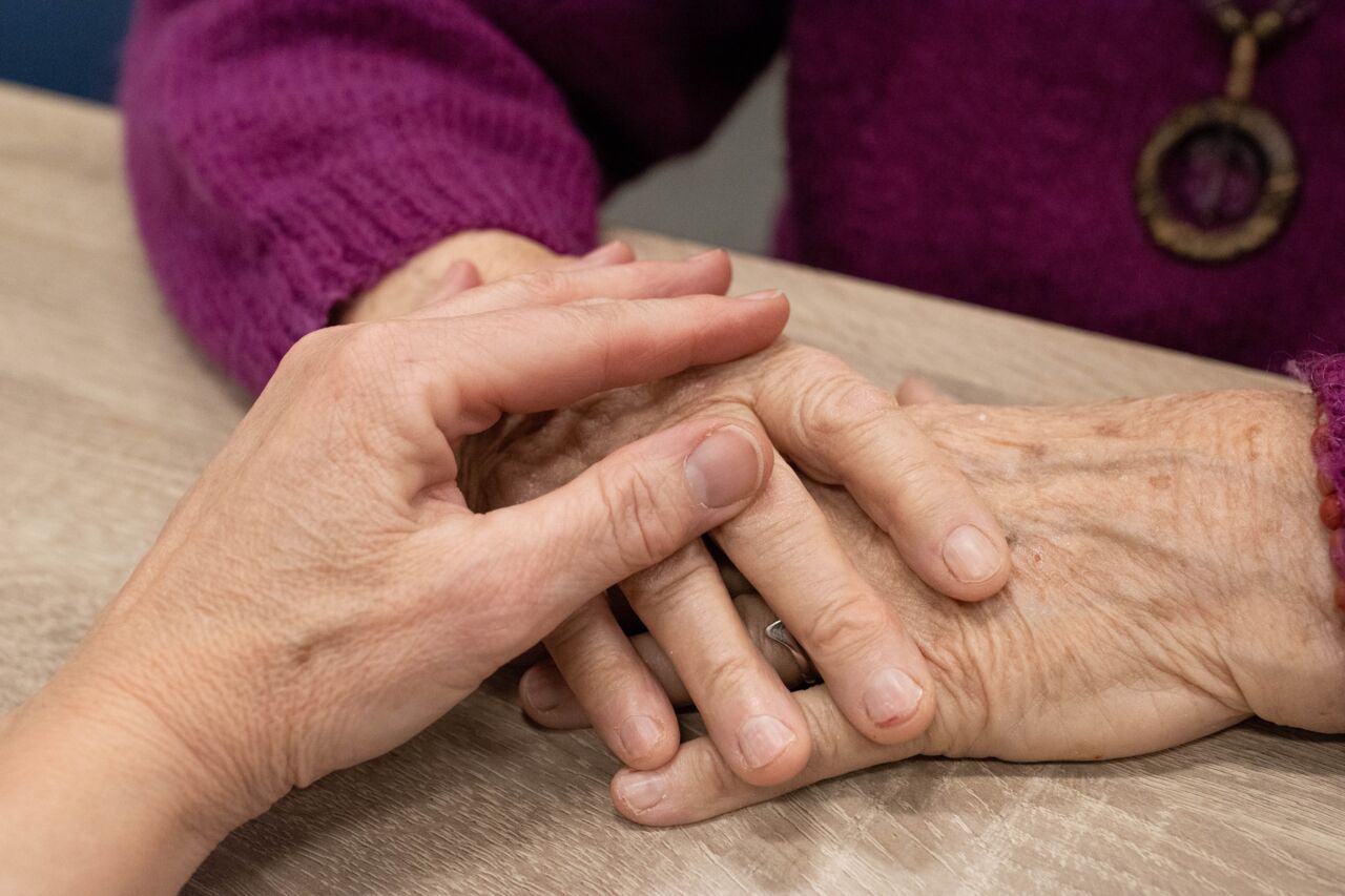Close up of two person's hands. They are holding each others hands.