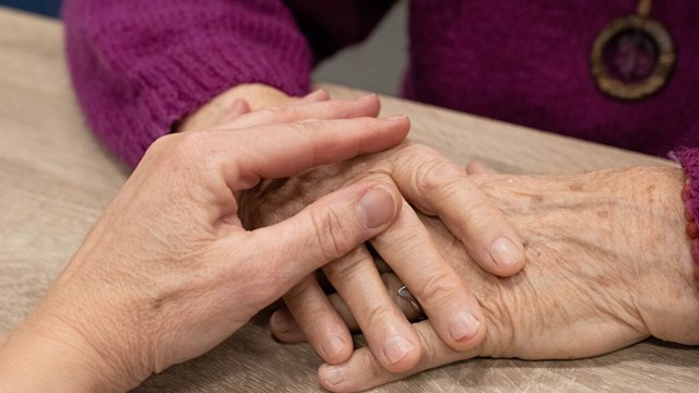 Close up of two person's hands. They are holding each others hands.