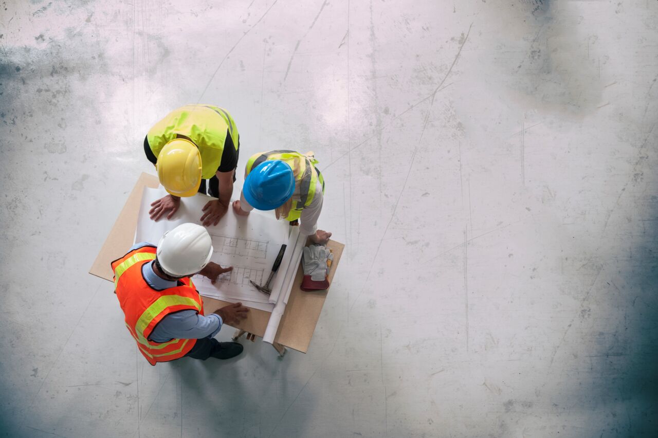 Byggarbetsplats med tre personer sedda från ovan.