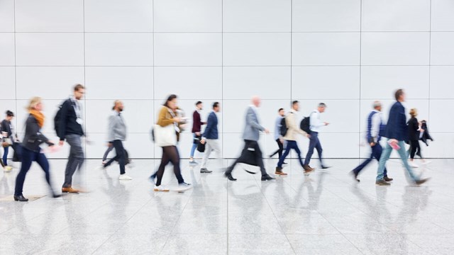 A group of people walking. The photo is a bit blurry, showing motion.