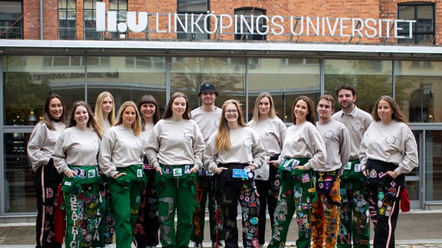 Smiling young people in front of building with the sign "LiU Linköpings universitet"
