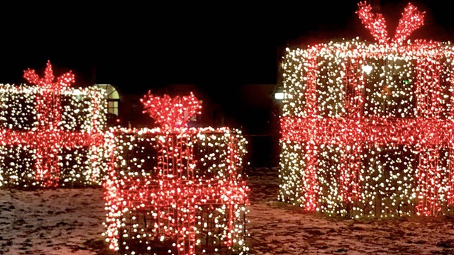 Juldekoration som föreställer lysande julklappar utomhus.