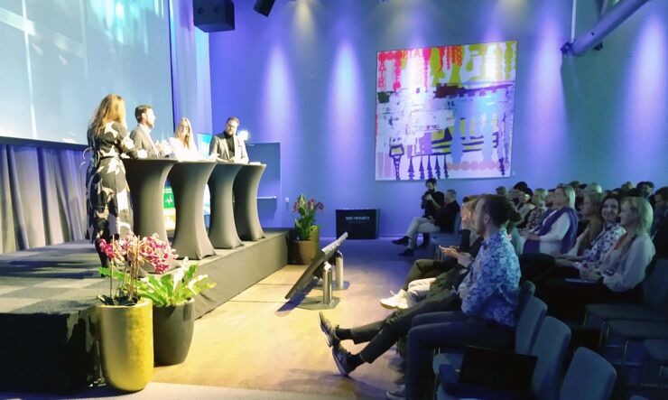 Fyra personer på en scen (panel) i en konferens.